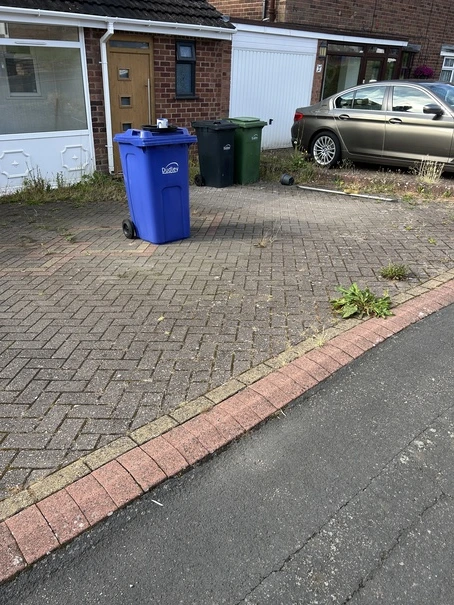 Dirty block paving driveway with weeds and moss in Dudley prior to pressure washing and restoration.