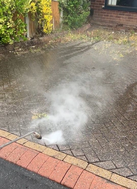 High pressure jet washing blasting away stubborn dirt and moss from block paving joints in Dudley.