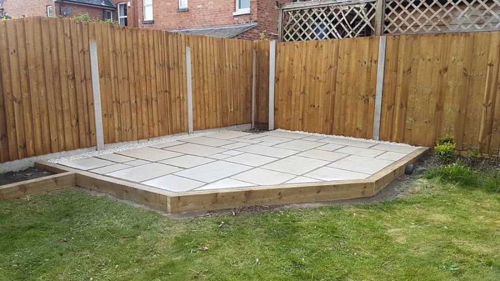 Raised patio with sleeper border installation in Blakedown